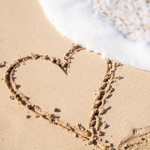Sand with heart drawn in the sand and waves coming over cpd courses